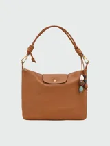 Bolso hobo de cuero color marrón, con asa corta y cierre con solapa y botón a presión.