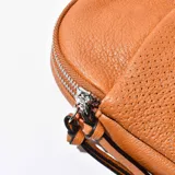 Porta celular marrón de cuero sintético con correa de tela estampada.