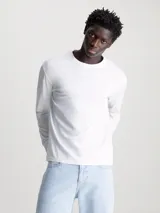 Remera blanca de manga larga Calvin Klein, corte regular fit, cuello redondo y logo estampado en el pecho.