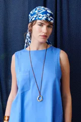 Top sin mangas color terracota con cuello redondo y bolsillo frontal. Presenta costuras a contratono en blanco que definen los bordes y el bolsillo.