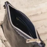 Cartera tipo baguette de cuero color rojo brillante, con correa de cadena plateada.