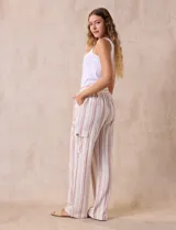 Pantalón cargo de lino color blanco, marca Marissa Olivia. Tiene pretina ancha elastizada con lazo de ajuste, bolsillos inclinados delanteros y bolsillos laterales con botón.