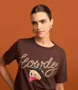 Remera alargada de algodón color marrón, con cuello redondo, mangas cortas y estampa frontal de un oso con sombrero de cowboy y la palabra "Howdy" escrita con una cuerda.