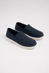 Mocasines náuticos azul marino con suela blanca.