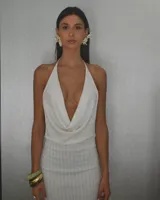 Minivestido blanco de tejido de punto calado, con escote halter y espalda descubierta.