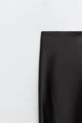 Conjunto de top con tirantes finos y falda larga con tajo lateral, ambos de seda color negro.
