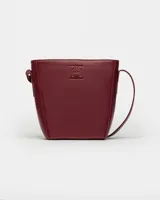 Cartera al hombro de cuero graneado en color bordó, diseño estructurado con asa ajustable.