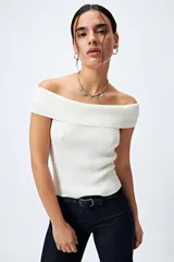 Top tejido color blanco con escote bardot que deja los hombros al descubierto y punto acanalado.