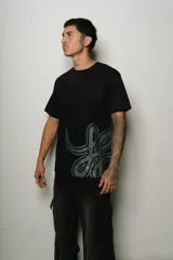 Remera negra de corte regular fit, confeccionada en jersey de algodón. Presenta un estampado plastisol de alta calidad en el frente.