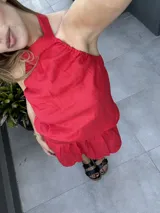 Falda roja corta acampanada de lino, con cintura alta y cierre invisible en la espalda.