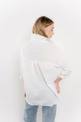 Camisa celeste de algodón liviano con bordado calado tipo broderie, manga larga con puño angosto y botones al frente.