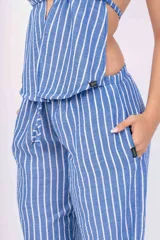 Pantalón palazzo celeste con rayas verticales blancas.