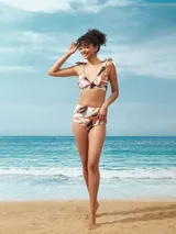 Top de bikini con estampado abstracto en tonos marrón, blanco y negro. Tiene corte triangular, breteles con lazos y copas removibles.