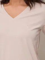 Remera color beige con cuello en V y mangas cortas.