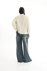 Sweater de punto calado color crema, con cuello alto y mangas largas.