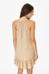 Vestido corto color beige, con escote halter, corte suelto y falda con volados.