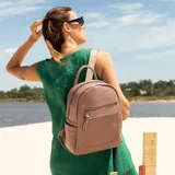 Mochila negra de símil cuero con bolsillo frontal con cierre. En su interior tiene dos bolsillos con cierre y uno abierto con división. Tiene asa de mano y correas regulables.