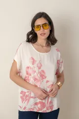 Blusa italiana de calce holgado, talle único, con cuello redondo y mangas cortas. Estampado de flores sobre fondo natural.