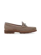 Mocasín de cuero negro con detalle de hebilla metálica plateada.