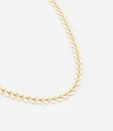 Collar dorado con capas de mini hojas.