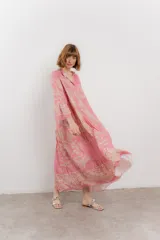 Vestido largo azul con estampado floral en tonos beige, confeccionado en viscosa. Presenta escote en V, botonadura completa en el frente y mangas largas con volados.