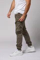 Pantalón cargo color beige de gabardina, con corte ajustado, bolsillos laterales con fuelle y puños elásticos en los tobillos.