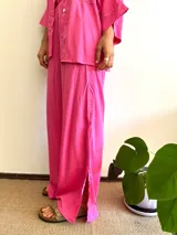 Pantalón fucsia de tela ligera con tajo lateral en la pierna, de corte amplio.