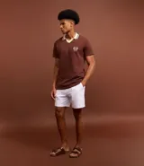 Camisa polo marrón con textura, cuello con detalle contrastante en beige y logo bordado en el pecho.