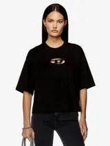 Camiseta negra de algodón orgánico, corte oversize y ligeramente cuadrado. Presenta un detalle de logotipo moderno con efecto 'peekaboo' en el pecho: un parche de la D ovalada, cortado a láser y bordado, que deja ver la piel debajo.