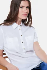 Camisa blanca de lino y algodón, con cuello clásico, mangas cortas y cierre frontal parcial con botones.