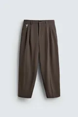 Pantalón marrón de corte ancho con pliegues frontales, cintura elástica, bolsillos laterales y traseros.