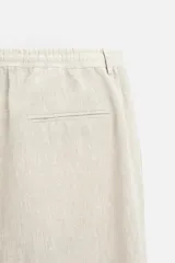 Pantalón de vestir color beige claro, de corte recto y confeccionado en lino.