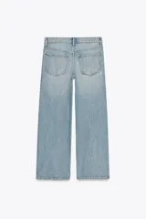 Pantalón de jean azul oscuro, de corte wide leg y tiro medio, con cinco bolsillos y cierre frontal con cremallera y botón metálico.