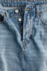 Pollera midi de denim celeste, de corte evasé, con tiro alto, cinco bolsillos y cierre frontal con botones.