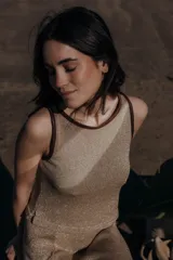 Top tejido color dorado con terminaciones en cuero marrón en cuello y sisas.