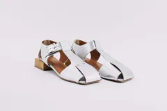 Sandalias de cuero negro con punta abierta y taco cuadrado de madera. Presentan tiras anchas en el empeine y ajuste con hebilla metálica.