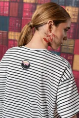 Remerón blanco con rayas horizontales negras, de corte recto y mangas cortas.