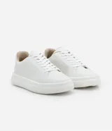 Championes blancos de cuero sintético con cordones y suela gruesa.