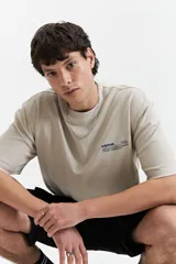 Remera beige de manga corta con cuello redondo y corte oversize.