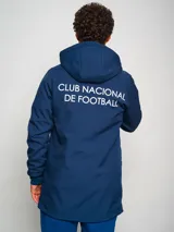 Parka azul con capucha, cierre frontal con cremallera y logo del Club Nacional de Football en el pecho.