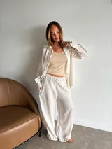 Camisa de manga larga color crudo o blanco roto, de tejido ligero con textura visible, corte holgado y cuello camisero.