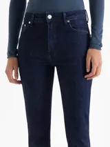 Jeans de mezclilla azul oscuro, tiro medio, con corte cropped y levemente acampanado en la botamanga.