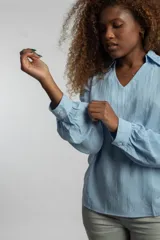 Camisa celeste de mangas largas con puños abotonados y cuello en V.