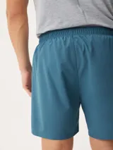 Short deportivo azul con cintura elástica y logo pequeño en la pierna.