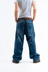 Pantalón de denim azul desgastado, corte mega baggy con bolsillos grandes y botones personalizados.