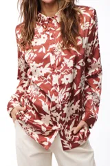 Camisa marrón con estampado floral blanco, de corte recto y mangas largas.