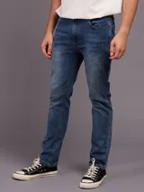 Pantalón jean celeste de corte slim fit y cintura media.