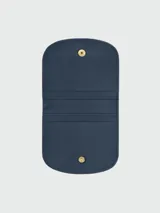 Tarjetero azul marino de cuero con logo de la marca grabado y botón dorado.