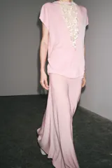 Top de punto color rosa, de cuello redondo y manga corta ancha.
