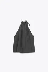 Top negro de tejido fluido con cuello halter ajustable con lazada.